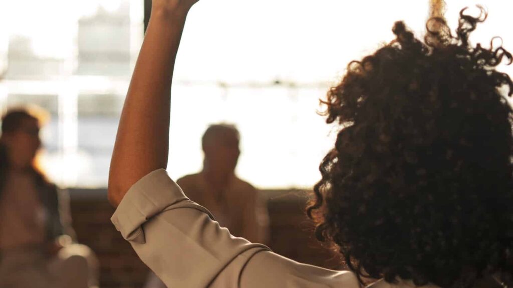 People raised their hand in a meeting