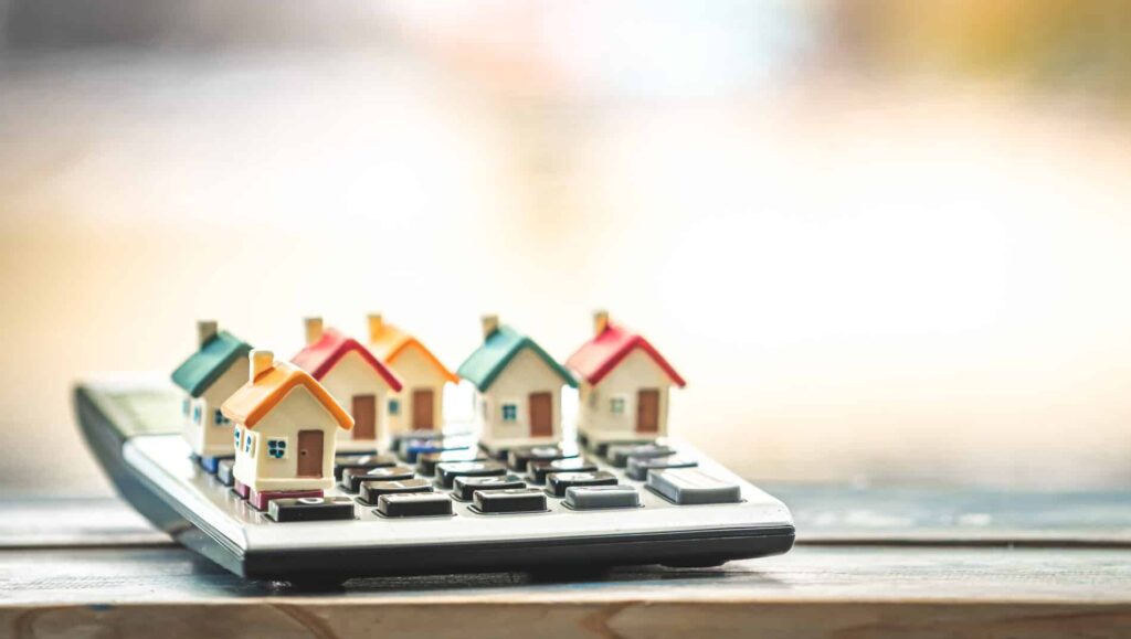 ็Many home model put on the calculator for select buy is owner in the public park, Loan for real estate or saving money for buy a new house to family in the future concept. financial services.
