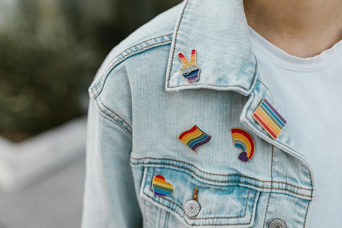 Denim jacket with rainbow Pride enamel pins