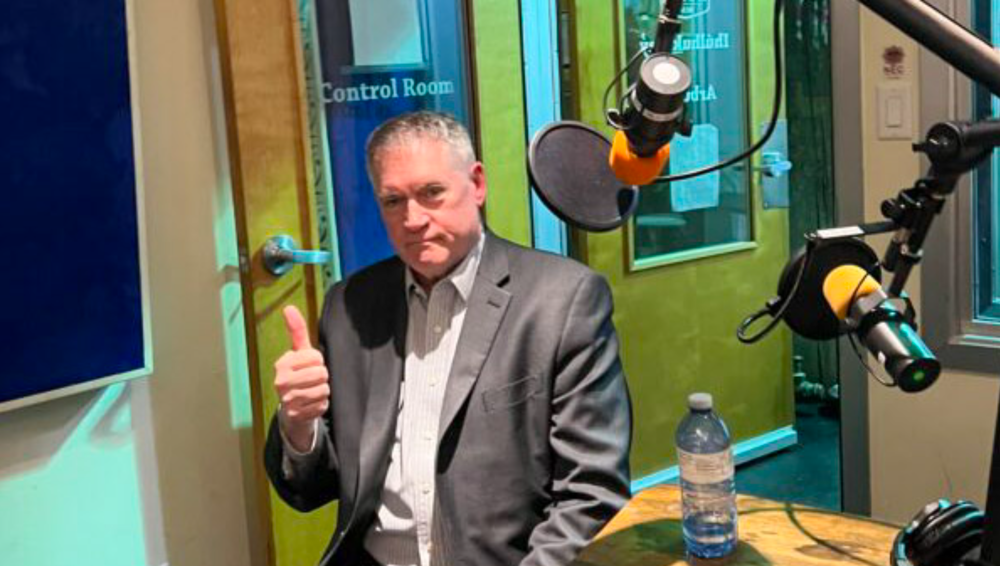 Thom Armstrong giving a thumbs up in a radio station control room