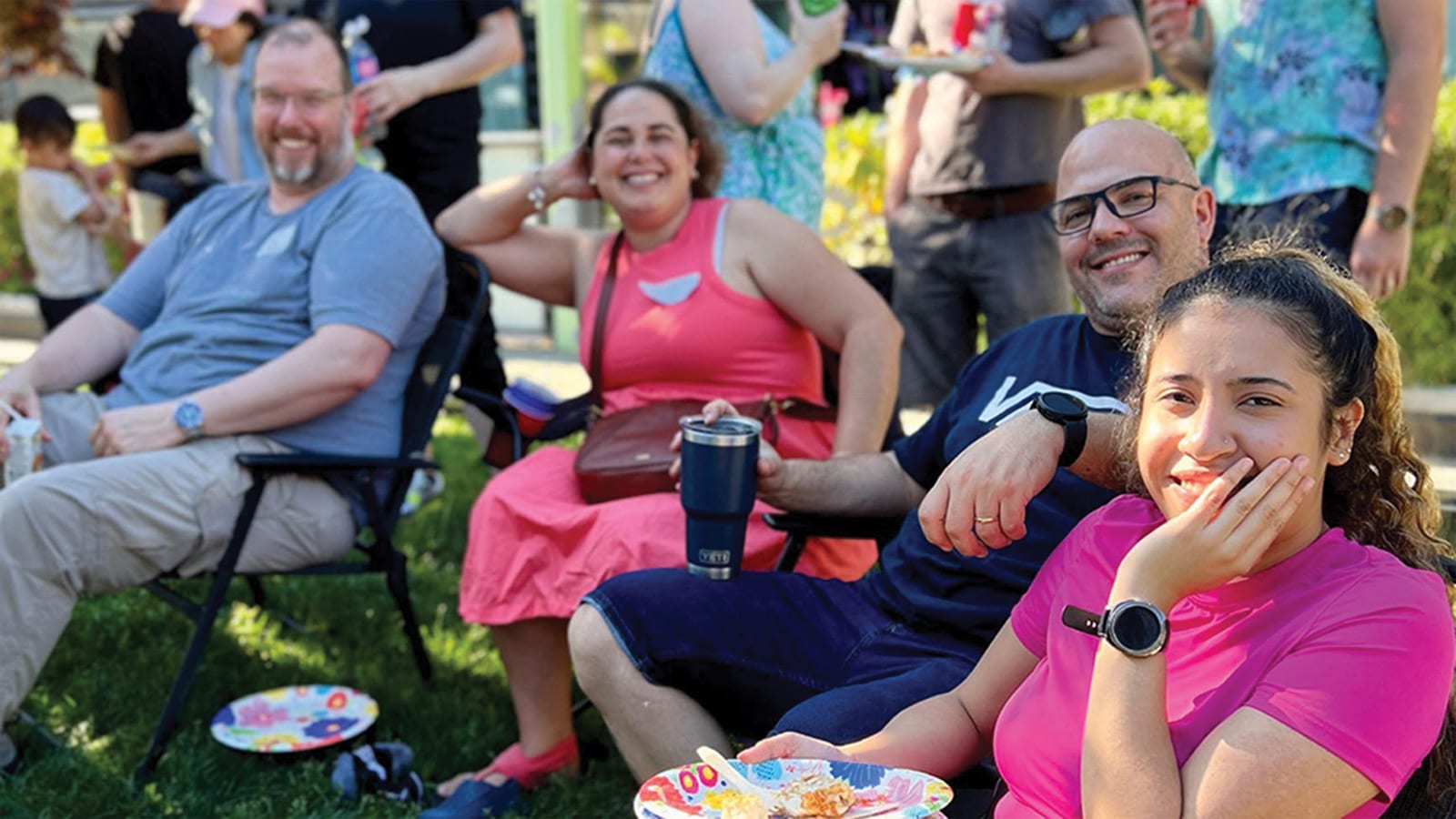 Members relaxing and laughing on the grass at a co-op barbecue