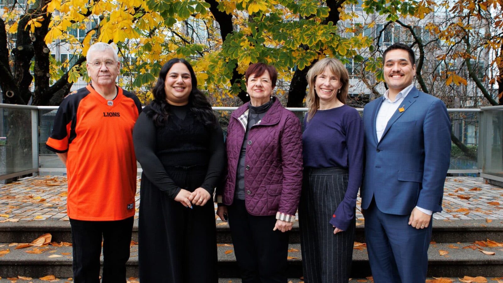 Five people standing together outdoors among autumn trees at the CHF BC Fall Conference