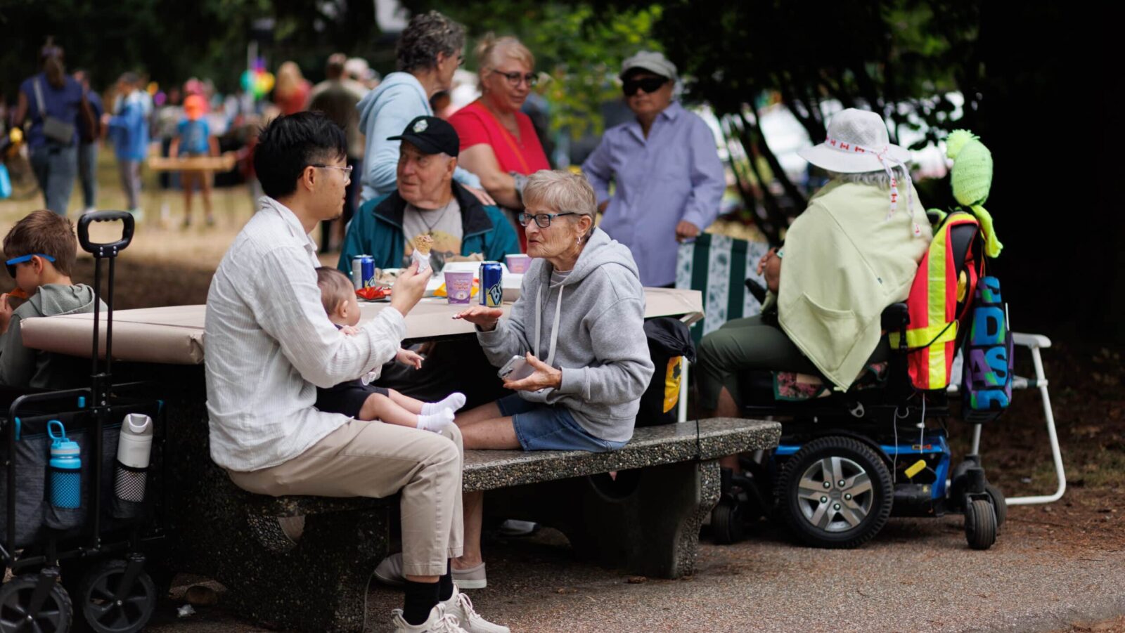 Members sharing food at outdoor picnic tables during the Mainland co-op barbecue