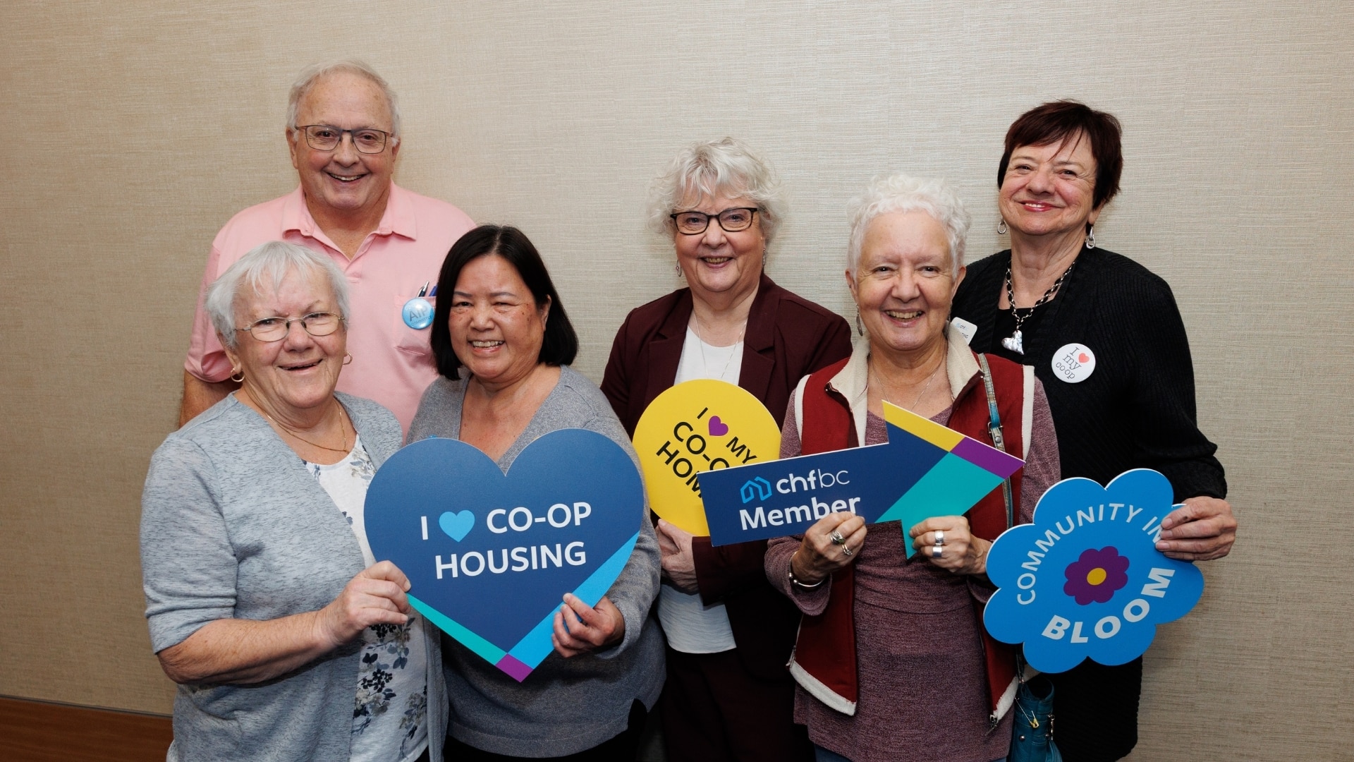 Co-op members holding "I love co-op housing" and Community in Bloom signs